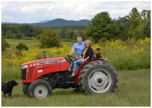 Two people on a tractor.