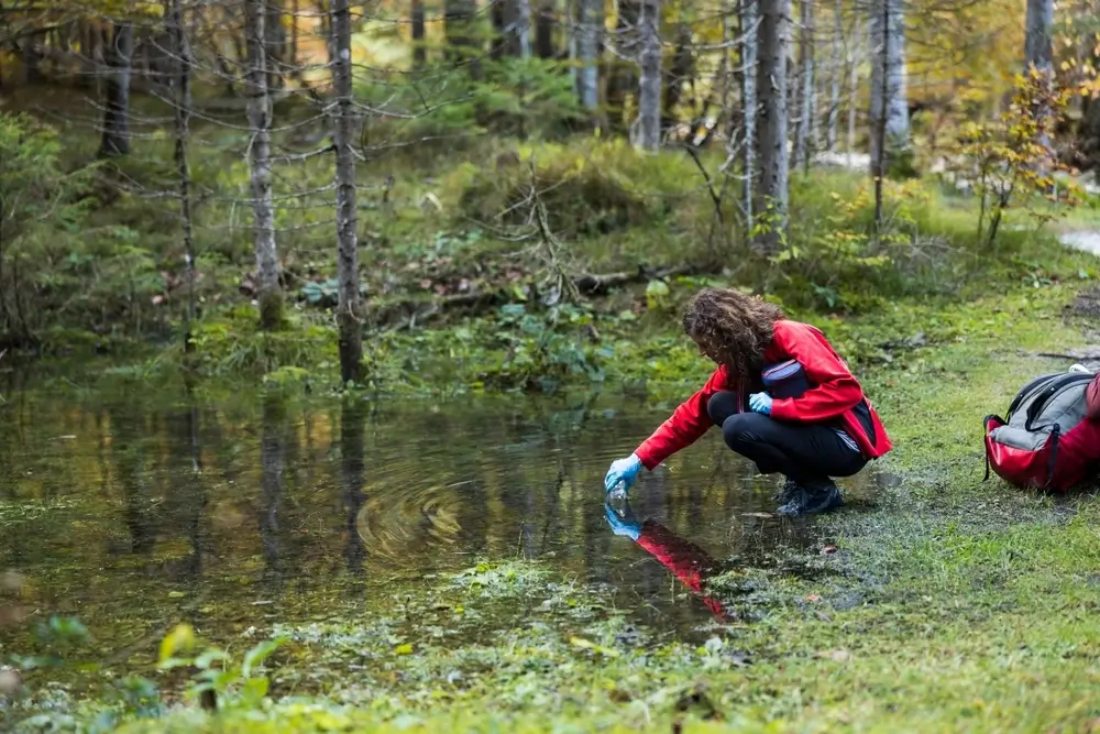 Person takes water sample.